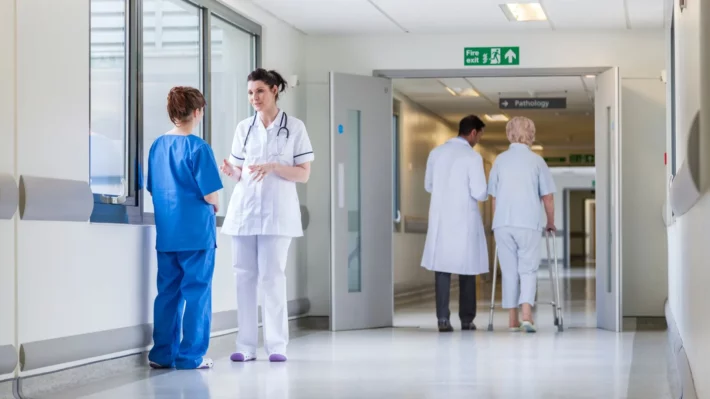 ACOs - Hospital setting with nurses and doctors in a hallwayy
